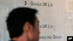 A man enters an office building with small Google UK Limited sign in London, Jan. 28, 2016. 
