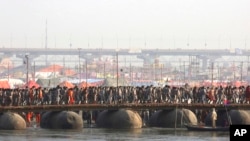 Naked Hindu holy men walk through a pontoon bridge as they return after ritualistic dips on auspicious Makar Sankranti day during the Kumbh Mela, or pitcher festival in Prayagraj, Uttar Pradesh state, India, Jan.15, 2019. 