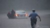 Un policía en Filadelfia intenta socorrer a un automovilista en medio de las inundaciones que causó la toermenta Isaías el 4 de agosto de 2020 en la costa atlántica de EE.UU.