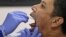 A man has his nasal swab sample collected by a health worker during a mass test for the new coronavirus at the local district office in Tanah Abang in Jakarta, Indonesia, June 21, 2020.