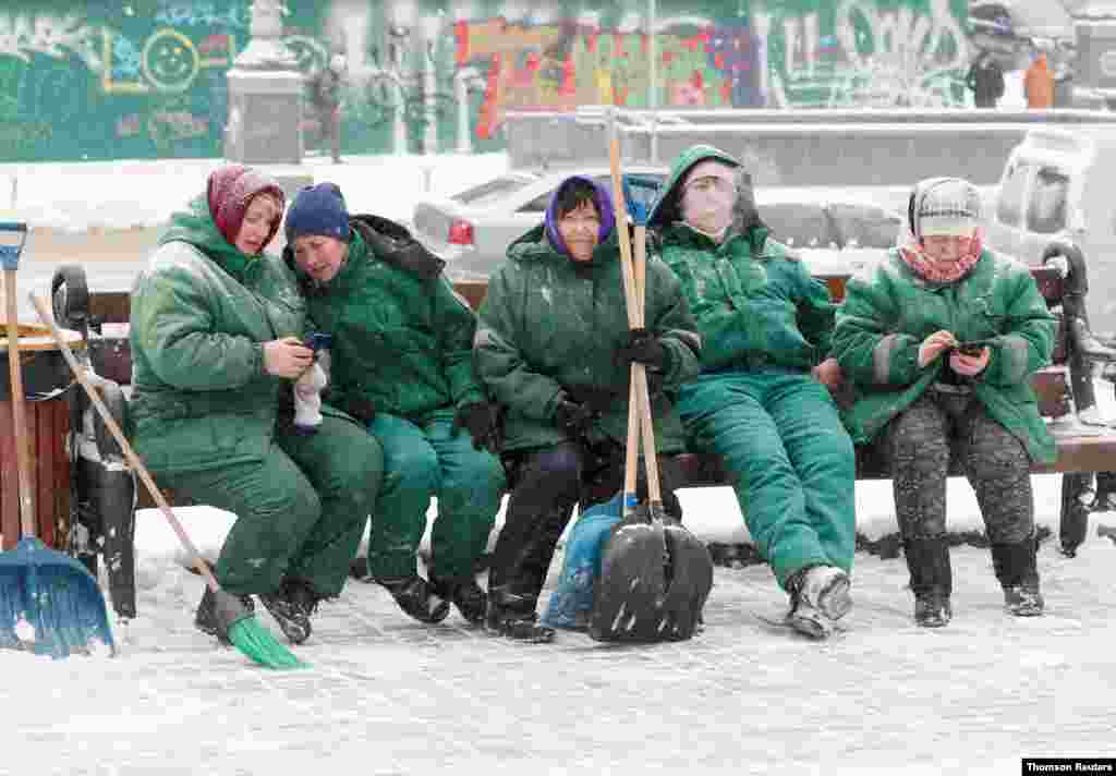 우크라이나 키예프 시 직원들이 눈을 치우다 휴식을 취하고 있다. 