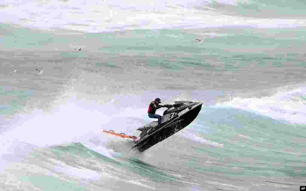 A rescuer on a jet ski battles rough seas while searching for a missing swimmer at Bondi Beach in Sydney, Australia. Police say a 22-year-old Japanese man went missing while swimming with a friend in rough surf on Nov. 4, 2013.