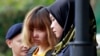 FILE - Vietnamese suspect Doan Thi Huong, center, detained in the investigation of Kim Jong Nam's assassination, is escorted by police officers out from Sepang court in Sepang, Malaysia, March 1, 2017.