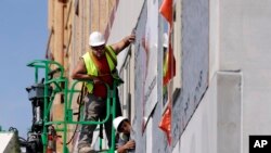 FILE - Workers build an apartment and retail complex in Nashville, Tenn., Oct. 6, 2017. 