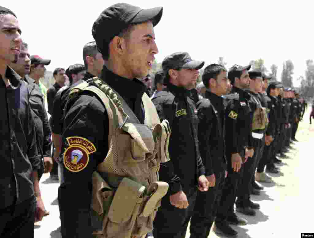 Shi'ite volunteers from Hezbollah Iraq who joined the Iraqi army to fight militants of the Islamic State, formerly known as the Islamic State in Iraq and the Levant, gather together in Baghdad, July 6, 2014.