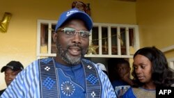 George Weah, à gauche, à côté de son épouse Clar devant leur maison à Monrovia, Liberia, 23 décembre 2017.