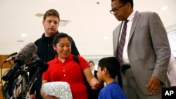 Beata Mariana de Jesus Mejia-Mejia, second from left, rubs her son Darwin Micheal Mejia's chin as she speaks at a news conference following their reunion at Baltimore-Washington International Airport, in Linthicum, Maryland, June 22, 2018.