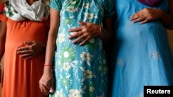 Surrogate mothers pose for a photograph inside a temporary home for surrogates.