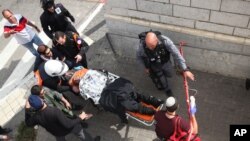 Israeli medics carry a wounded Israeli following a stabbing attack in a light rail train in Jerusalem, Nov. 10, 2015. 