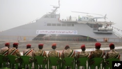 Members of Iran's Revolutionary Guard sit in front of a newly inaugurated high-speed catamaran, in the port city of Bushehr, northern Persian Gulf, Iran, Sept. 13, 2016.