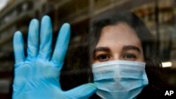 In this Thursday, April 16, 2020 photo, chemist Amaya Pascual poses for a photograph in her pharmacy in Pamplona, northern Spain. 