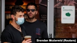 People wear masks against the coronavirus disease (COVID-19), following the CDC recommendation that fully vaccinated Americans wear masks as the highly transmissible Delta variant has led to a surge in infections, in Times Square in New York City, New York, U.S., July 27, 2021.