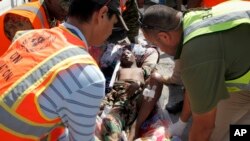 FILE - U.N and other aid personnel assist a wounded young man after he and others were airlifted to Mogadishu for treatment, following attacks on two restaurants in the city of Baidoa, at the airport in Mogadishu, Somalia, Feb. 29, 2016. 