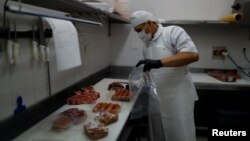 Gustavo, a butcher who works at the Don Julio steakhouse's butcher shop, prepares an order, as the spread of the coronavirus disease (COVID-19) continues, in Buenos Aires, Argentina May 11, 2020. (REUTERS/Agustin Marcarian)