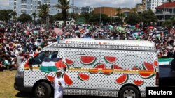 FILE - A boy holds a Palestinian flag as he walks past a minibus painted with watermelon in solidarity with the Palestinians at Sea Point promenade during a global day of action amid the ongoing conflict between Israel and Hamas, in Cape Town, South Africa, January 13, 2024.