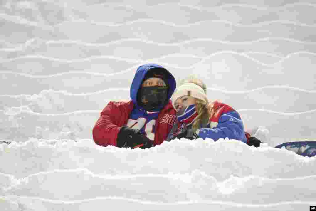 Buffalo Bills fans sit on snow covered seats as they watch players warm up before an NFL football game between the Bills and the San Francisco 49ers in Orchard Park, New York, Dec. 1, 2024.