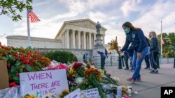 19일 미국 워싱턴 대법원 앞에 전날 타계한 루스 베이더 긴즈버그 대법관을 추도하는 시민들이 꽃을 놓았다.