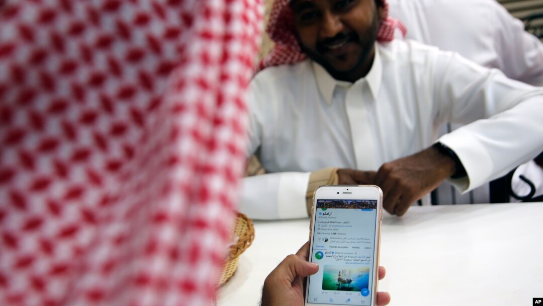 Seorang pria membaca Twitter Aramco di sebuah kafe di Jeddah, Arab Saudi, 3 November 2019. 