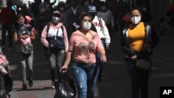 Personas con mascarillas caminan por el centro de Quito, la capital de Ecuador, el lunes 14 de septiembre de 2020. El gobierno ecuatoriano levantó este día el estado de excepción impuesto por el covid, hace seis meses.