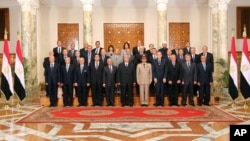 This image released by the Egyptian Presidency on July 16, 2013 shows interim President Adly Mansour, center, with his new cabinet ministers at the presidential palace in Cairo, Egypt.