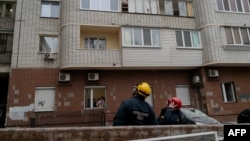 Ukrainian rescuers inspect damage to a residential building following a drone attack in Kyiv on Jan. 10, 2025, amid the Russian invasion of Ukraine. 