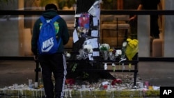 A fan stands in front of a makeshift memorial outside the hotel where former One Direction singer Liam Payne was found dead after falling from a balcony, in Buenos Aires, Argentina, the morning after his death, Oct. 17, 2024.