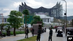 Tentara memperketat penjagaan di dekat istana presiden baru (latar belakang) seusai upacara peringatan HUT ke-79 kemerdekaan Indonesia di ibu kota Nusantara (IKN), Kalimantan, Sabtu, 17 Agustus 2024. (Achmad Ibrahim/AP)