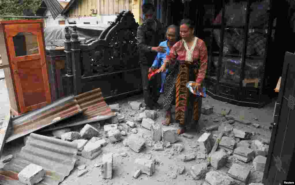 Warga meninggalkan rumah yang rusak karena gempa kuat di kabupaten Bener Meriah, Aceh bagian tengah (2/7).