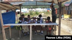 Sekelompok anak-anak pelajar sekolah dasar yang berteduh pada salah satu bangunan kayu seusai pulang sekolah di kawasan pengungsian Balaroa, Palu Barat, Sulawesi Tengah, 22 Juli 2019. (Foto: Yoanes Litha/VOA)