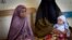 A Somali mother and her older child wait in line for her baby to receive a five-in-one vaccine against several potentially fatal childhood diseases, at the Medina Maternal Child Health center in Mogadishu, Somalia Wednesday, April 24, 2013. (AP Photo/Ben) 