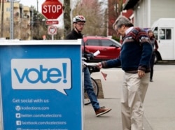 FILE - Voters drop off ballots in the Washington State primary, in Seattle, March 10, 2020.