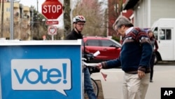 Voters drop off ballots in the Washington State primary, March 10, 2020 in Seattle. Washington is a vote by mail state.