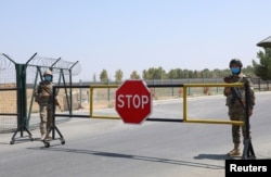 FILE - Border guards are seen at a checkpoint at the Uzbekistan-Afghanistan border in Ayritom, Uzbekistan, Aug. 15, 2021.