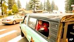 A Tahoe resident lies in a pick-up truck while evacuating as the Caldor Fire approaches South Lake Tahoe, Calif., Aug. 30, 2021.