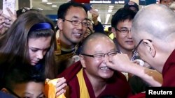 Exiled Tibetan spiritual leader the Dalai Lama (C) pinches the nose of a supporter as he is surrounded by security staff after arriving at Sydney International airport June 4, 2015, at the start of a twelve-day visit to Australia. REUTERS/David Gray 