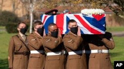 The coffin of Captain Tom Moore is carried by members of the Armed Forces during his funeral, at Bedford Crematorium, in Bedford, England, Feb. 27, 2021. 