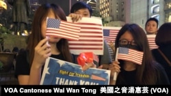 Manifestatnes en Hong Kong sostienen banderas de y carteles agradeciendo a EE.UU. por apoyar la democracia en Hong Kong.