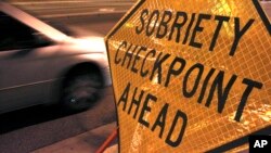 FILE - А car approaches a sobriety checkpoint set up along a busy street in Albuquerque, New Mexico, Dec. 29, 2011.