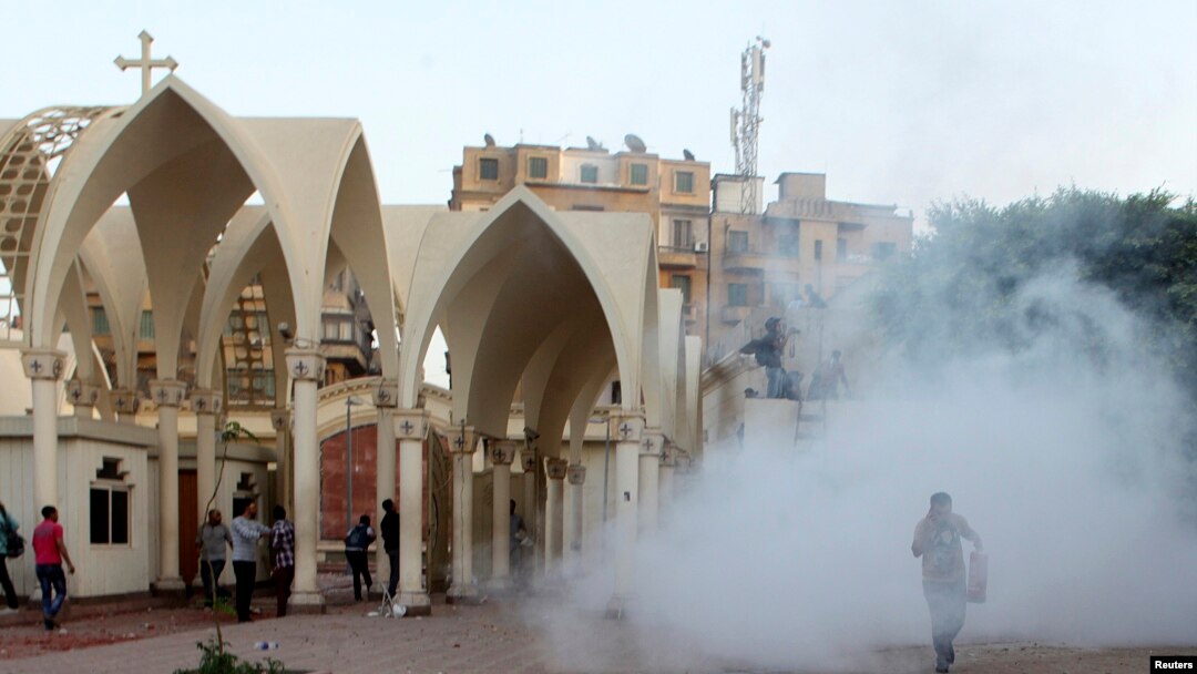 Anggota kelompok Kristen Koptik lari ke dalam katedral di Kairo saat polisi melemparkan gas air mata di tengah perseteruan dengan kelompok Muslim (7/4). (Reuters/Asmaa Waguih) 