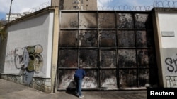 Seorang warga menatap gardu listrik yang terbakar setelah terjadinya pemadaman listrik yang meluas di Caracas, Venezuela, 11 Maret 2019 (foto: Reuters/Carlos Jasso)