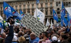 FILE - A sign derogatory of African migrants is seen at a rally organized by Lega leader Matteo Salvini, in Milan, Italy, May 18, 2019.