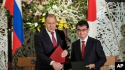고노 다로 일본 외무상(오른쪽)과 세르게이 라브로프 러시아 외무장관이 지난 3월 도쿄에서 공동기자회견을 마친 후 악수하고 있다.