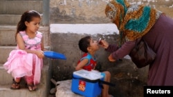 ເດັກຊາຍຄົນນຶ່ງ ໄດ້ຮັບການຢອດຢາວັກຊິນ ຕ້ານໂຣກໂປລິໂອ ຈາກພະນັກງານແພດ ໃນຊ່ວງທີ່ມີການປຸກລະດົມ ຕ້ານໂຣກໂລປິໂອ ຢູ່ໃນຄຸ້ມຂອງຄົນມີລາຍຮັບຕໍ່າ ຢູ່ນະຄອນກາຣາຈີ ປາຫິສຖານ ໃນວັນທີ 9 ເມສາ 2018