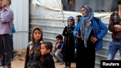 FILE - Syrian refugees are seen gathered for a news conference by visiting U.N. High Commissioner for Refugees Filippo Grandi (not pictured), at the Al Zaatari refugee camp, in the Jordanian city of Mafraq, near the border with Syria, Feb. 12, 2018.