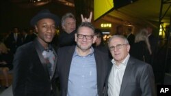 FILE - Singer Jon Bon Jovi photobombs a group photo of, from left, Aloe Blacc, Lucian Grainge and Irving Azoof at a gala in Nov. 5, 2015. (Photo by Matt Sayles/Invision for City of Hope/AP Images)