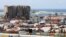 Des véhicules roulent près du silo à grains qui a été endommagé lors de l'explosion du port de Beyrouth, à Beyrouth, au Liban, le 9 avril 2021.