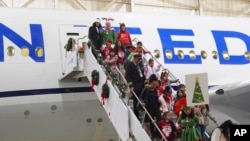 Participants deplane during the United Airlines annual "fantasy flight" to a fictional North Pole at Denver International Airport, in Denver, Colorado, Dec. 14, 2024.