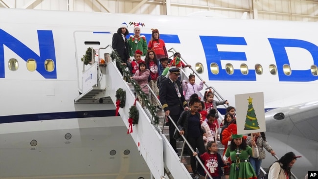 Participants deplane during the United Airlines annual "fantasy flight" to a fictional North Pole at Denver International Airport, in Denver, Colorado, Dec. 14, 2024.