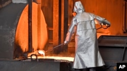 FILE - A worker controls iron at the Thyssenkrupp steel factory in Duisburg, Germany, April 27, 2018. 