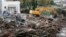 A mechanical digger clears away debris from trees in a stream near a house the day after torrential rains caused flooding in Biot, France, Oct. 5, 2015. 